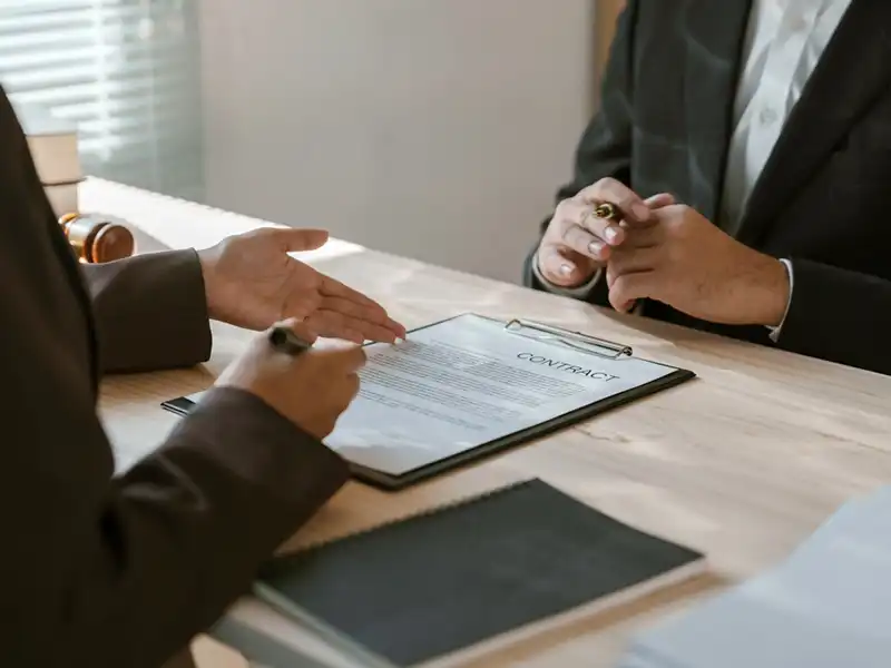 An image of two people inspecting a  contract document prior to signature.
