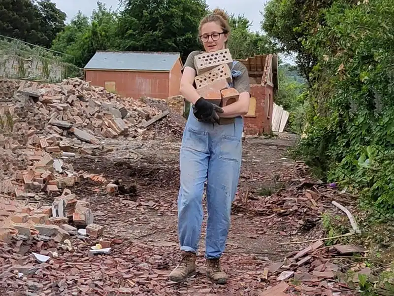 Allotment Collective Project Leader Sophie Read recovering bricks from the Bicclescombe site.